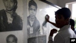 ពលរដ្ឋ​ខ្មែរ មើល​រូបថត​​ជន​រងគ្រោះ​​នៅ​ក្នុង​របប​ខ្មែរ​ក្រហម​​ដែល​ដាក់​តាំង​នៅ​សារមន្ទីរ​ទួលស្លែង​ ក្នុង​រាជធានី​ភ្នំពេញ។