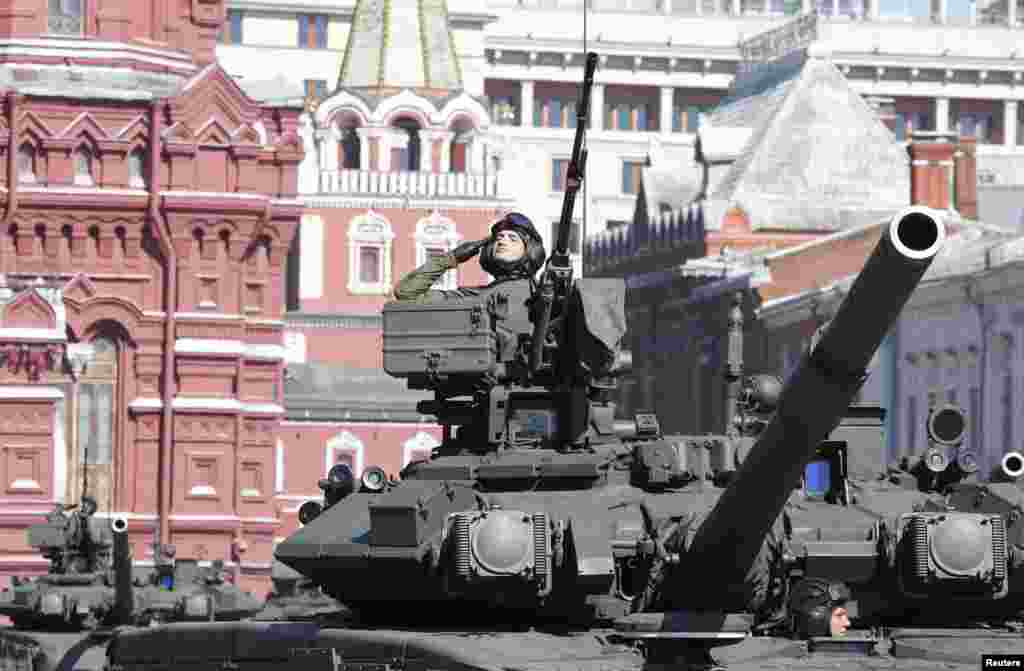 Seorang anggota militer Rusia memberikan hormat dari atas kendaraan lapis baja, dalam&nbsp; parade peringatan Hari Kemenangan Rusia di Lapangan Merah, Moskow, Rusia.