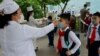 Anak-anak SD di Pyongyang, Korea Utara diperiksa suhu tubuhnya sebelum masuk ke kelas mereka (foto: dok). 