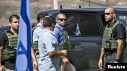 Perdana Menteri Israel Benjamin Netanyahu (tengah) keluar dari mobilnya yang dikelilingi penjaga saat akan menghadiri pertemuan dengan militer di Nablus, Tepi Barat (6/10). (Reuters/Baz Ratner)