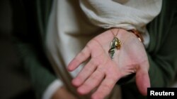 FILE - Arab-Israeli poet Dareen Tatour, 35, holds a map-shaped necklace charm with a Palestinian flag and "Palestine" written in Arabic during an interview with Reuters at her house in Reineh, northern Israel September 26, 2017. 