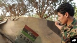 A Libyan rebel looks at the tail of a rebel MIG-23 jet in Benghazi on June 26, 2011 at the site where the jet crashed after it was shot down on March 19, 2011.