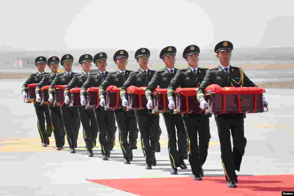 Soldiers of the Chinese People's Liberation Army (PLA) carry caskets that arrived from South Korea, containing the remains of Chinese soldiers who fought in the Korean War, at an airport in Shenyang, Liaoning province.