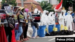 Warga desa Lakardowo bersama aktivis lingkungan Ecoton, menggelar aksi dan teaterikal di depan gedung negara Grahadi, Surabaya, 17 November 2016, menuntut penutupan pabrik pengolahan limbah B3 yang diduga mencemari lingkungan (Foto: VOA/Petrus).