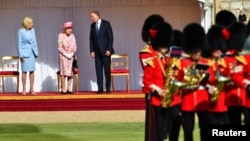 Presiden AS Joe Biden dan Ibu Negara Jill Biden (kiri) menerima penyambutan kehormatan saat menghadiri jamuan Ratu Elizabeth II di Kastil Windsor, hari Minggu (13/6). 