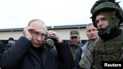 블라디미르 푸틴(왼쪽) 러시아 대통령이 20일 랴잔 지역에 있는 서부군관구 훈련소를 방문해 사격 시범을 위해 보안경을 착용하고 있다. 