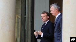 French President Emmanuel Macron, left, and NATO Secretary-General Jens Stoltenberg walk out of the lobby after a meeting at the Elysee Palace in Paris, Nov. 28, 2019.