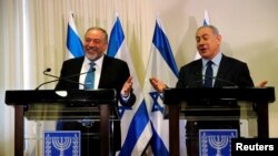 Avigdor Lieberman, head of the Yisrael Beitenu party, left, and Israeli Prime Minister Benjamin Netanyahu talk to reporters after signing a coalition deal to broaden the government's parliamentary majority at the Knesset in Jerusalem, May 25, 2016. 