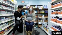 FILE - Michelle Melton, who is 35 weeks pregnant, receives the Pfizer-BioNTech vaccine against the coronavirus disease (COVID-19) at Skippack Pharmacy in Schwenksville, Pennsylvania, Feb. 11, 2021.