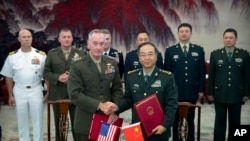 នាយ​ឧត្តមសេនីយ៍​ Joseph Dunford (កណ្តាលឆ្វេង) ​ និង​នាយឧត្តមសេនីយ៍​ Fang Fenghui ចាប់ដៃគ្នា​បន្ទាប់ពី​ពិធីចុះហត្ថ​លេខាព្រមព្រៀង​ដើម្បី​ពង្រឹង​ទំនាក់ទំនង​រវាង​កងទ័ពប្រទេស​ទាំងពីរ​(ស.រ.អា និងចិន)។