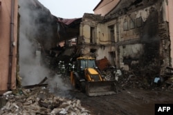A digger arrives to help rescuers remove rubble from a school destroyed during an overnight missile attack on the town of Slоviansk, Donetsk region, Ukraine, on Feb. 18, 2024.
