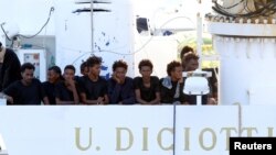 Les migrants attendent de débarquer du navire "Diciotti" au port de Catane, en Italie, le 22 août 2018. 