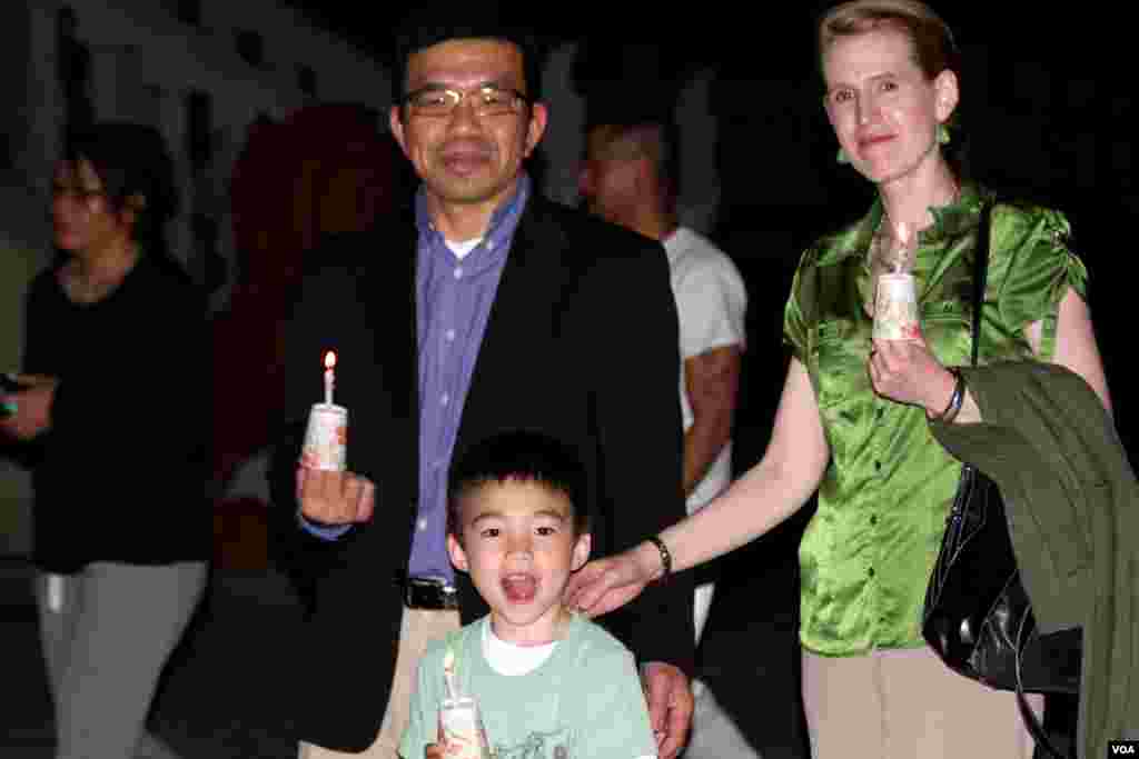 អ្នកស្រី Rachel Chung (ស្តាំ) និង​ស្វាមី Sambath Chung (ឆ្វេង) និង​កូនប្រុស​​អាយុ​៥​ឆ្នាំ Sorya Chung ​ពិធី​ដង្ហែ​ភ្លើង​ទៀន​ជុំវិញ​ព្រះវិហារ​ក្នុង​អំឡុង​បុណ្យ​ទក្ខិណានុប្បទាន​​នៅ​វត្ត​ពុទ្ធិការាម​នៅ​ក្រុង Silver Spring រដ្ឋ​ Maryland កាល​ពី​ថ្ងៃ​សុក្រ​ទី​១៧ ខែ​មេសា ឆ្នាំ​២០១៥ ដើម្បី​ប្រារព្ធ​ខួប​ទី​៤០​នៃ​ការ​ឡើង​កាន់កាប់​អំណាច​របស់​ខ្មែរ​ក្រហម​និង​ឧទ្ទិស​កុសល​ដល់​ជន​រង​គ្រោះ​ទាំង​អស់។ (សឹង សុផាត/VOA)