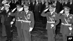 FILE – Two surviving leaders of a 1980 military coup, Gens. Kenan Evren, center, and Tahsin Sahinkaya, second from right, were sentenced Wednesday to life in prison for crimes against the state by a court in Ankara, Turkey, June 18, 2014.