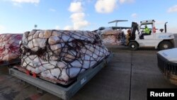 FILE - Workers load humanitarian aid from the United Nations onto a plane for Syrian families in Arbil airport, about 220 miles north of Baghdad, Dec. 15, 2013. A key Syrian adviser criticized such aid Thursday.