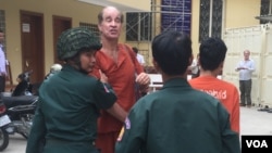 អ្នកផលិត​ភាពយន្ត​​ឯកសារ​សញ្ជាតិ​អូស្រា្តលី​ ​លោក​​ James Ricketson​ ​ដែល​មន្ត្រី​ជាន់​ខ្ពស់​របស់​រដ្ឋាភិបាល​កម្ពុជា​ចោទ ថា ​ជា​​អ្នកផ្តល់​ព័ត៌មាន​សម្ងាត់​ដល់​លោក​ ​សម រង្ស៊ី​ ​ត្រូវ​បាន​មន្ត្រី​ពន្ធនាគារ​នាំ​យក​​មក​បង្ហាញ​ខ្លួន​ ​នៅ​តុលាការ​កំពូល​នៅ​ព្រឹក​ថ្ងៃពុធ​ ទី១៧ ខែមករា ឆ្នាំ២០១៨។ (ហ៊ុល រស្មី/VOA)