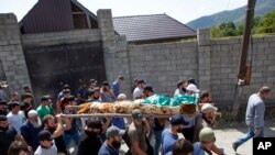 People carry the body of Zelimkhan Khangoshvili, a Chechen Georgian who fought against Russia in the Second Chechen War and had links with Georgian intelligence, during his funeral in Duisi village, Georgia, Aug. 29, 2019.