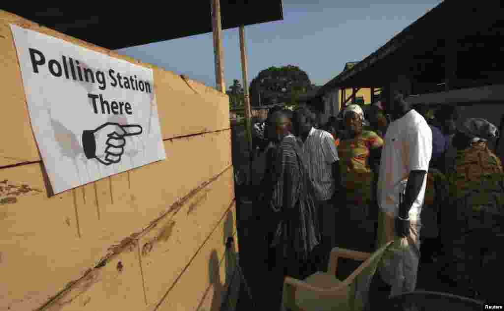 People wait to vote at a polling station in Kibi, eastern Ghana, December 7, 2012. 