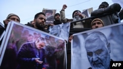 Protesters shout slogans against the United States and Israel as they hold posters with the image of top Iranian commander Qasem Soleimani, who was killed in a US airstrike in Iraq, and Iranian President Hassan Rouhani during a demonstration in the…