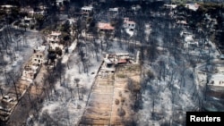 An aerial view shows burnt houses and trees following a wildfire in the village of Mati, near Athens, Greece, July 25, 2018. 