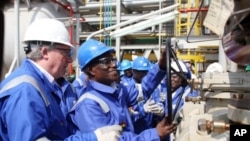 Ghanaian President John Atta Mills (2nd R) turns a valve at FPSO Kwame Nkrumah oil rig at the Jubilee field in Takoradi, 15 Dec 2010
