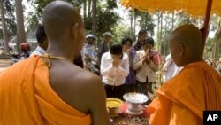 FILE - Cambodian Buddhist monks bless to Buddhist followers near Bayon temple in Siem Reap province, about 320 kilometers (199 miles) north of Phnom Penh, Cambodia, Tuesday, April 27, 2010.
