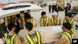 FILE - Airport personnel load a coffin into an ambulance at the Noi Bai airport, Nov. 27, 2019 in Hanoi, Vietnam. It contained the body of one of the 39 Vietnamese migrants who had been found dead in a truck in Britain. 