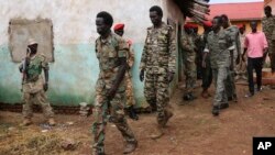 FILE - South Sudanese soldiers accused of a horrific attack on foreign aid workers including rape, torture, killing and looting on the Terrain hotel compound, are assisted to a prison van after attending their trial in Juba, South Sudan.