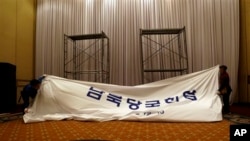 Pekerja Korea Selatan membongkar papan nama di tempat yang semula akan digunakan untuk pertemuan tingkat tinggi pertama Korea di Hotel Grand Hilton di Seoul, Korea Selatan (12/6).