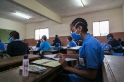 FILE - Students wear face masks as a preventive measure against the spread of the COVID-19 coronavirus in their classroom at the Jean Benoit College in Yaoundé, Cameroon, on June 1, 2020.