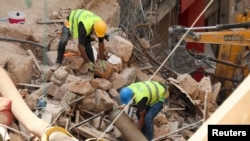 FILE - Volunteers dig through the rubble of buildings which collapsed due to the explosion at the port area, after signs of life were detected, in Gemmayze, Beirut, Lebanon, Sept. 5, 2020.