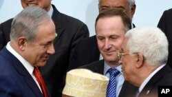 FILE — Israeli Prime Minister Benjamin Netanyahu, left, talks with Palestinian President Mahmoud Abbas, right, at the COP21, the U.N. Climate Change Conference, in Le Bourget, outside Paris, Nov. 30, 2015.