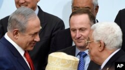 Le Premier ministre israélien Benjamin Netanyahu, à gauche, s’entretient avec le président palestinien Mahmoud Abbas, à droite, à la COP21, la Conférence U.N. Changement climatique, Le Bourget, près de Paris, 30 novembre 2015. 