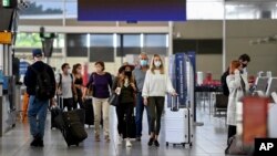 Passengers wear face masks as they arrive at the departures terminal at Sydney Domestic Airport in Sydney, Australia, Nov. 5, 2021. 