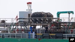 FILE - Malaysian marine police officers inspect the Naniwa Maru 1 at Klang port, Malaysia after the Singapore-owned tanker was robbed by pirates, April 23, 2014. 