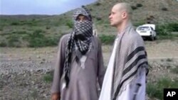 Image prise à partir d'une video obtenue par le site internet La Voix du Djihad. Le sergent Bowe Bergdahl avec un taliban dans l'est de l'Afghanistan. (AP Photo/Voice Of Jihad Website via AP video)