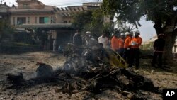 Petugas keamanan memeriksa puing-puing mobil di lokasi ledakan bom, di Islamabad, Pakistan, Jumat, 23 Desember 2022. (Foto: AP)