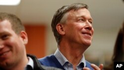 FILE - Former Colorado Gov. John Hickenlooper waits to speak at the Story County Democrats' annual soup supper fundraiser, Feb. 23, 2019, in Ames, Iowa. 