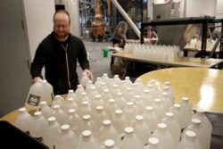 Workers bottle hand sanitizer produced by J. Rieger and Co., a Kansas City, Mo. distillery, March 20, 2020. People waited as long as two hours to buy the sanitizer, made from overproof gin, in response to the coronavirus pandemic.