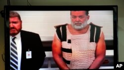 Colorado Springs shooting suspect Robert Lewis Dear, right, appears via video before Judge Gilbert Martinez, with public defender Dan King, at the El Paso County Criminal Justice Center for this first court appearance.