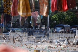 Riot police stand in formation in front of road barricade, as protesters hang women's clothings overhead to mark the International Women's Day in Yangon, Myanmar, March 8, 2021.