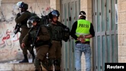 FILE - Israeli soldiers detain a local Palestinian cameraman during clashes with Palestinians in the village of Tuqu, near Bethlehem, in the Israeli-occupied West Bank, Jan. 25, 2019.