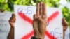 An anti-coup protester shows the three-fingered salute of resistance during a strike walk with slogans to protest the military coup, in Yangon, Myanmar, April 9, 2021. 