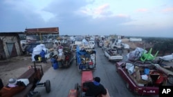 Truk-truk warga sipil mengungsi dari serangan militer Suriah di provinsi Idlib di jalan utama dekat Hazano, Suriah, 24 Desember 2019. (Foto: dok).