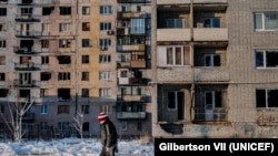 A child walks past a residential building, nicknamed the 'storybook' that was destroyed by shelling and is now occupied by Ukrainian forces in Avdiivka, Donetsk Oblast, Ukraine, Saturday 25 November 2017. Avdiivka, a city of about 20,000 people, sits righ