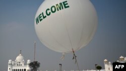 A worker walks in front of the Shrine of Baba Guru Nanak Dev at the Gurdwara Darbar Sahib ahead of its opening in the Pakistani town of Kartarpur near the Indian border, Nov. 6, 2019. 