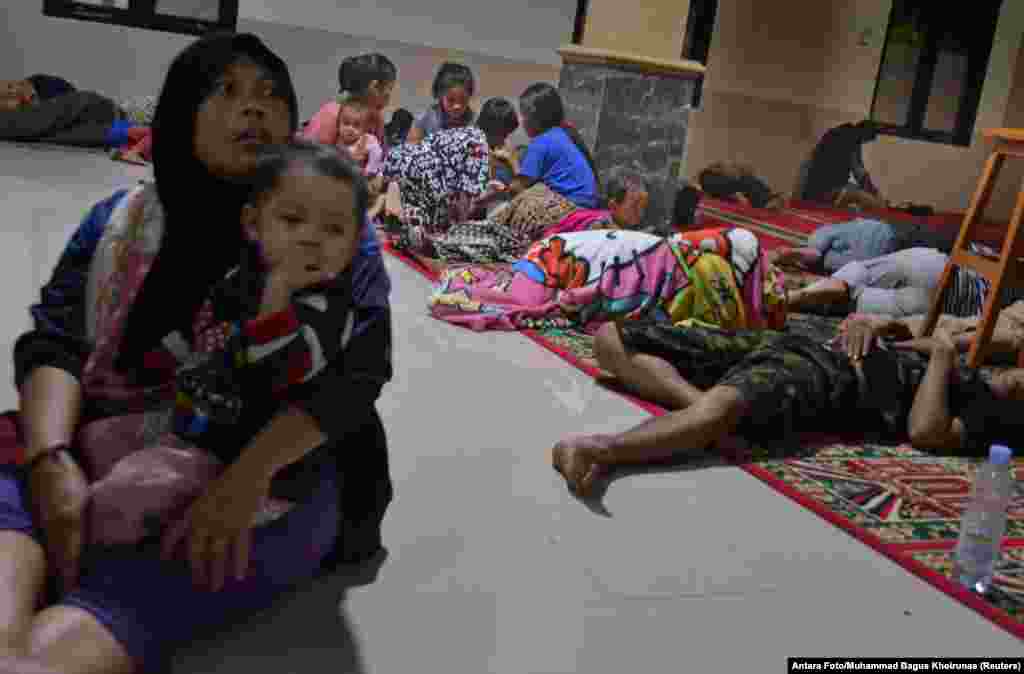 Residents sit inside a mosque where they evacuated following high waves and the eruption of the Krakatoa volcano at Labuan district in Pandeglang regency, Banten province, Indonesia, Dec. 22, 2018.