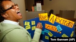 Transfer student Tina Wright, a senior in Criminology, lets out a scream after adding her reason to scream on the board at a "Stress Blowoff" event at the student union on the University of Missouri in St. Louis.