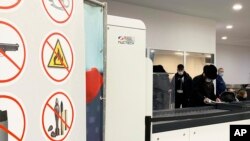 FILE - Passengers walk next to Nuctech security scanners at the Brussels Eurostar train terminal on Monday, Jan. 17, 2022. 