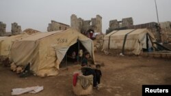 FILE - Abeer abo Almajed, 10, sits in front of her family's tent in Babisqa, in the northern countryside of Idlib, Syria, Nov. 29, 2021.